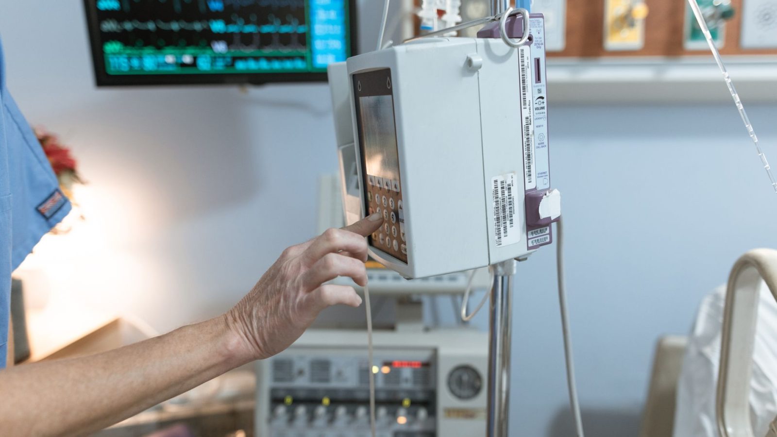 A healthcare worker operates a modern infusion pump in a hospital setting, ensuring precise medication delivery.