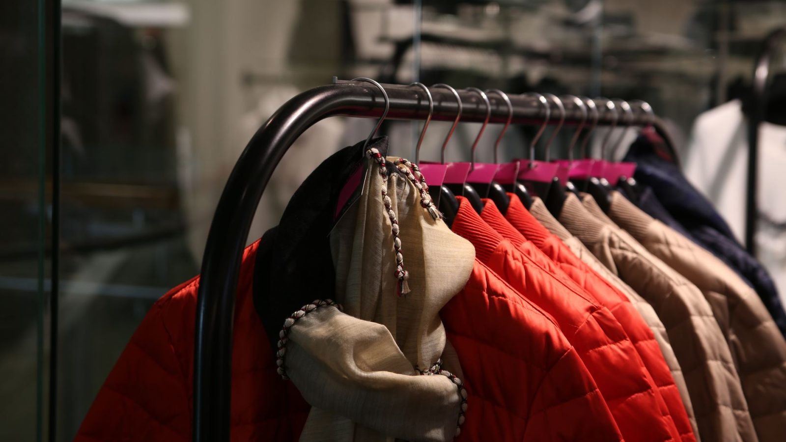 A variety of colorful jackets hanging on a clothes rack in a stylish store.