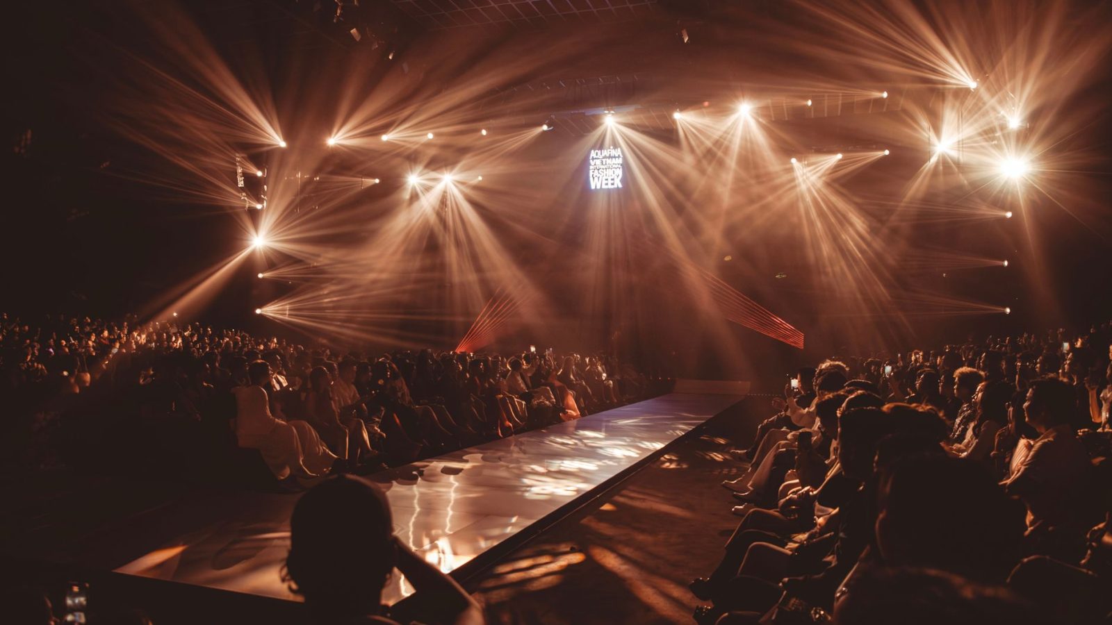 Exciting fashion show event with dazzling lights and a captivated audience.