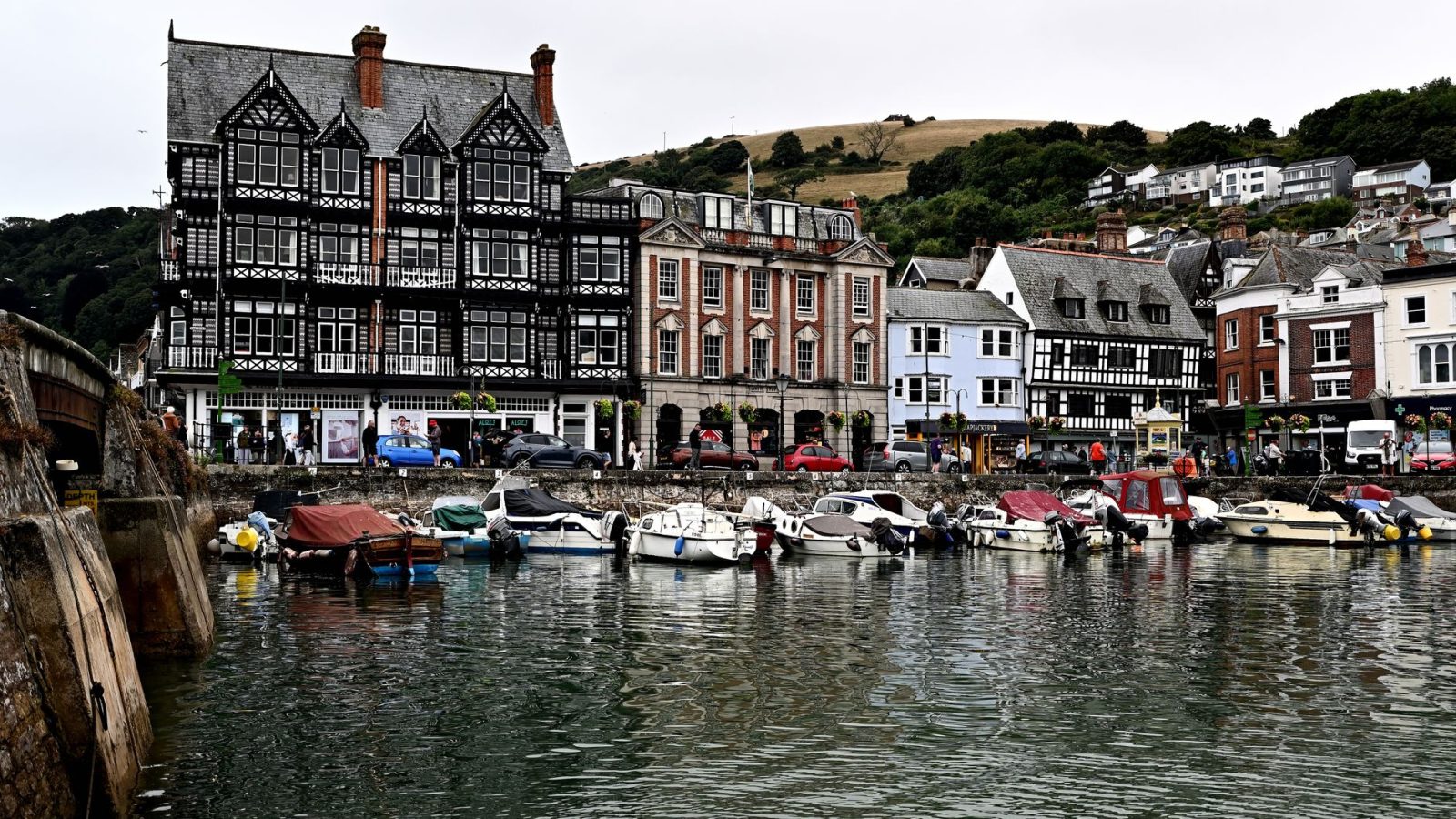 Picturesque view of Dartmouth Harbour with boats and historic buildings reflecting in the water.