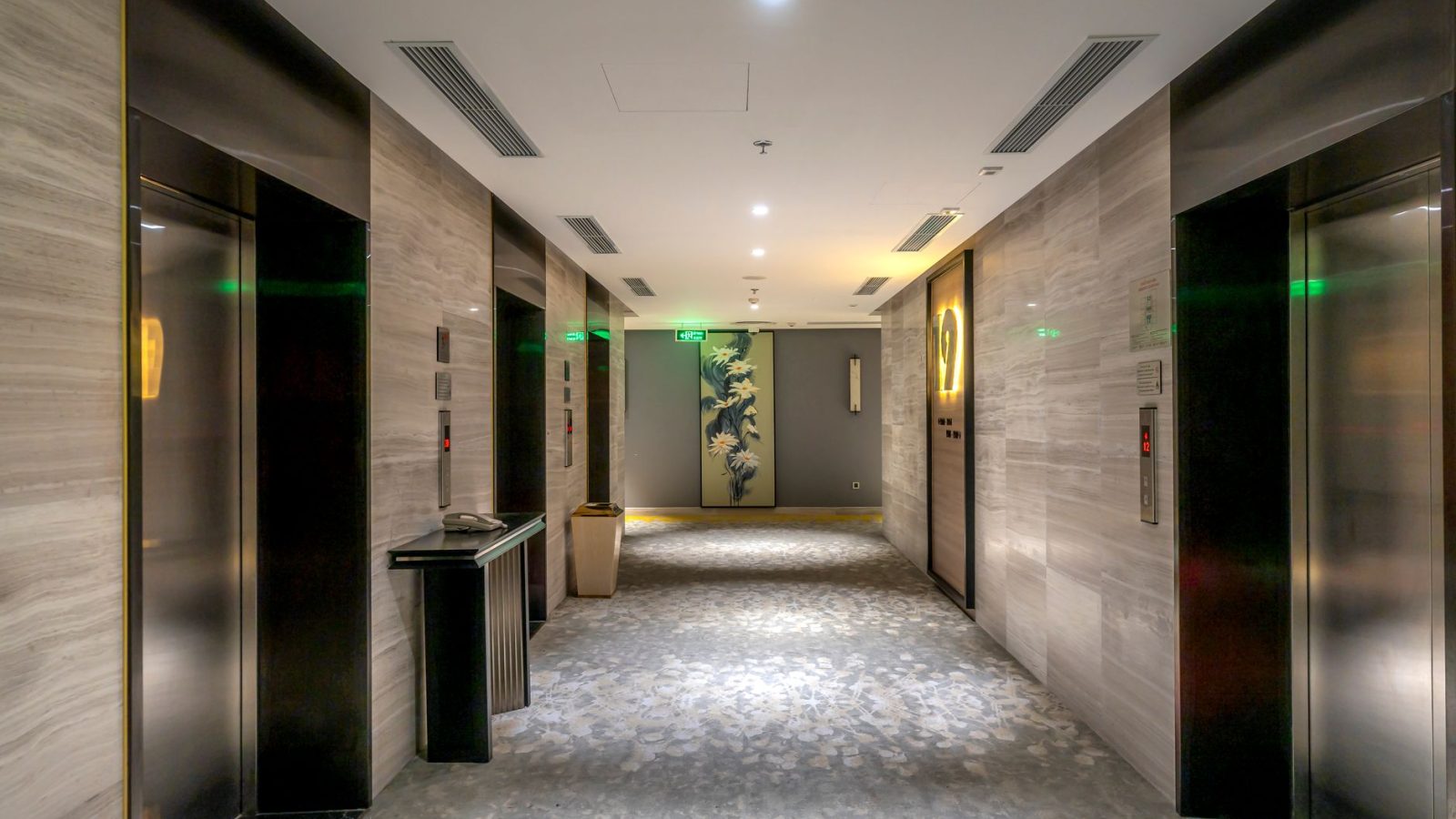 Spacious hotel hallway with elevators and contemporary decor.