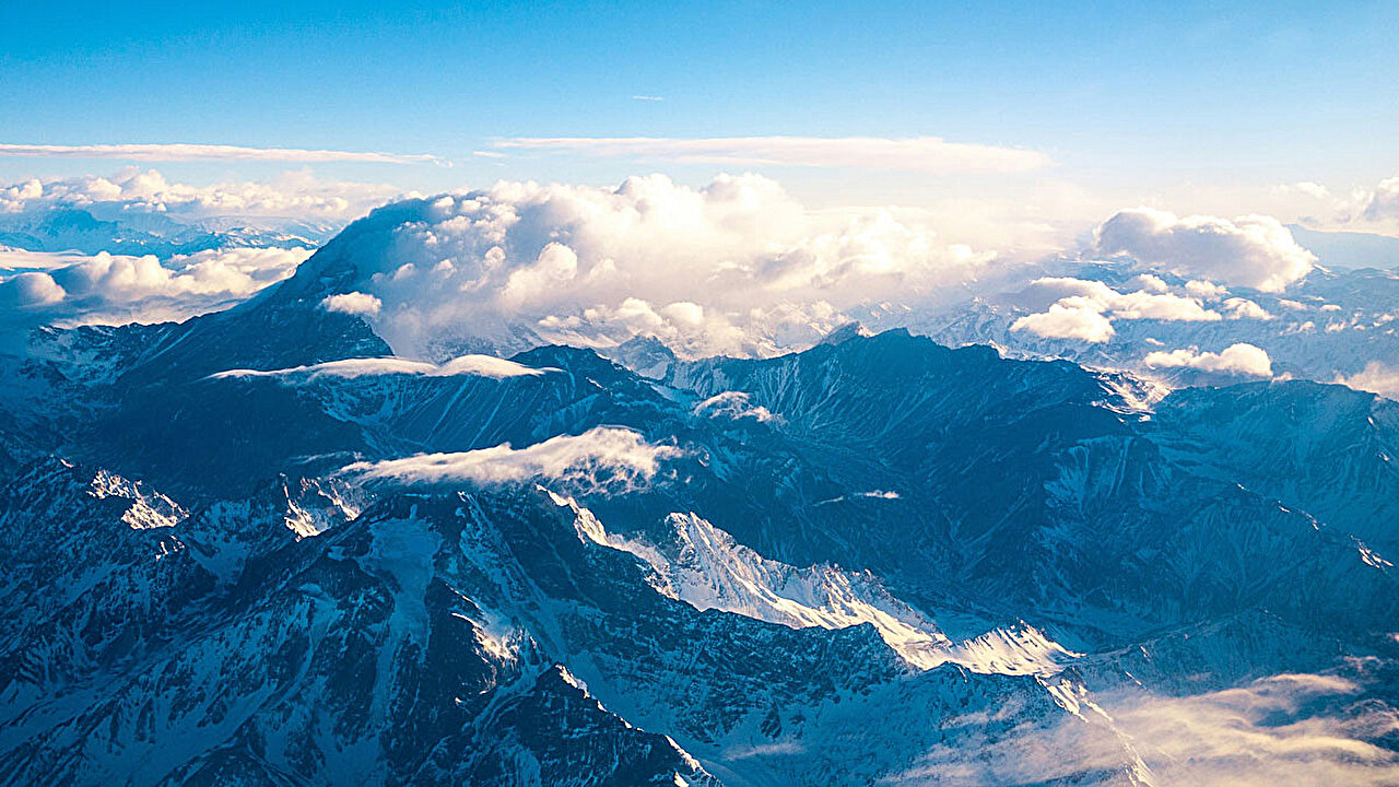 Supercooled clouds over the highest mountains respond differently to climate change